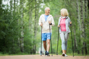 A senior man and woman walking in the woods to ease joint pain