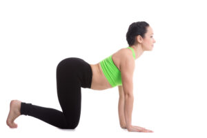 Young woman doing a cow yoga stretch for arthritis